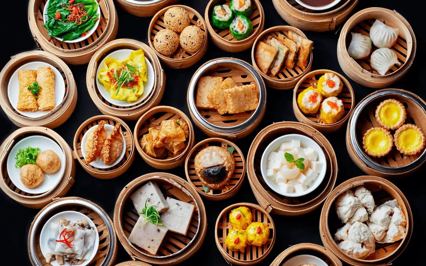 A top-down view of assorted Cantonese dim sum served in bamboo steamers